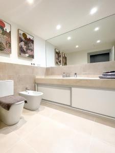 a bathroom with a toilet and a sink and a mirror at B-Rent Oasis Emma's Suite - 5 People in Corralejo +23 photos