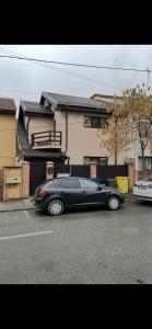 a black car parked on the side of a street at Villa Apartments in Craiova