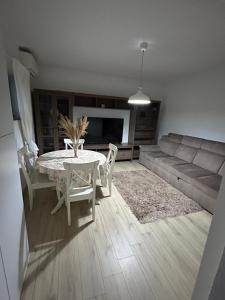 a living room with a table and a couch at Villa Apartments in Craiova