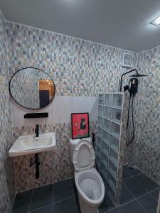 a bathroom with a toilet and a sink and a mirror at The Lamoon Residence samui in Lamai