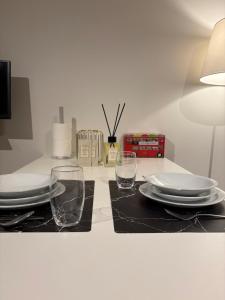 a table with two glasses and plates and a lamp at Briefstreet - Louvain in Leuven