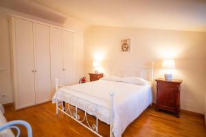 a bedroom with a white bed and a wooden floor at La Torretta del Sementone in Assisi