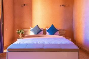 a bedroom with a bed with blue and purple pillows at Luxury Villa - Pool Atlas Views & Wakeboard Lake in Marrakech +44 photos