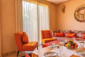 a living room with a table and a couch at Luxury Villa - Pool Atlas Views & Wakeboard Lake in Marrakech