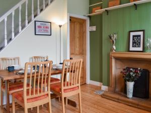 een eetkamer met een tafel en stoelen bij Almond Cottage in Holker