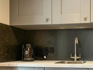 a kitchen counter with a coffee maker next to a sink at Studio On The Green - Uk48298 in Chinley