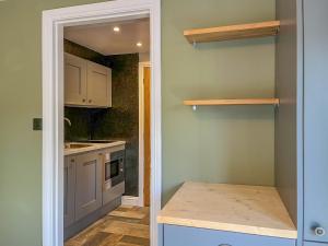 a kitchen with white cabinets and a kitchen island at Studio On The Green - Uk48298 in Chinley