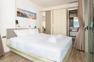 ein Schlafzimmer mit einem weißen Bett mit Handtüchern darauf in der Unterkunft Modern condo with full sea view, 4 min walk to Kamala beach in Kamala Beach + 28 Fotos