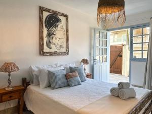 een slaapkamer met een bed met een schilderij aan de muur bij Vila Saruê in Búzios