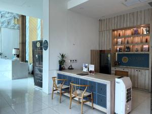 eine Küche mit einer Theke mit 2 Stühlen und einem Tisch in der Unterkunft Modern condo with full sea view, 4 min walk to Kamala beach in Kamala Beach