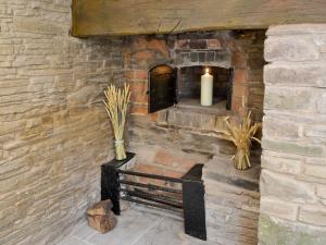 eine Steinmauer mit einer Bank und einer Kerze in der Unterkunft Mill Cottage in Peterchurch