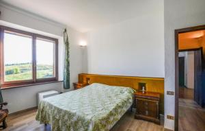 4 Bedroom Stunning Home In Roccastrada في روكاسترادا: غرفة نوم بها سرير ونافذة