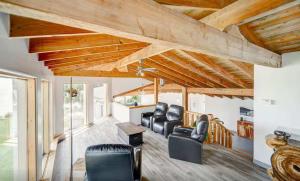 a living room with leather chairs and wooden ceilings at Heated Indoor Pool - Maison au Bord du Lac in Rigaud