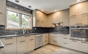 a kitchen with wooden cabinets and stainless steel appliances at Heated Indoor Pool - Maison au Bord du Lac in Rigaud