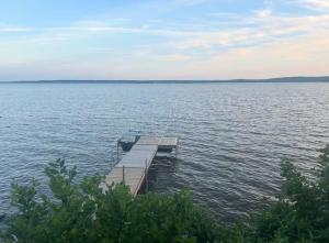 a dock in the middle of a large body of water at Heated Indoor Pool - Maison au Bord du Lac in Rigaud