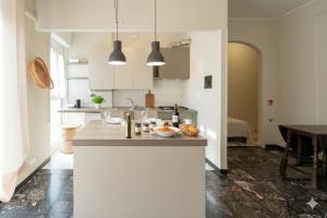 een keuken met witte kasten en een aanrechtblad bij Cycling Riviera apartment in Imperia