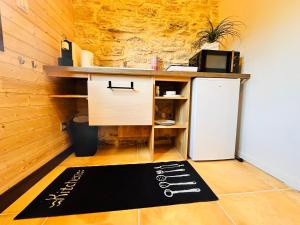 a kitchen with a refrigerator and a rug on the floor at Chez Vivi in Gindou