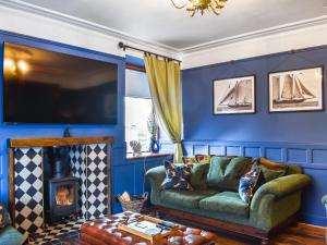 a living room with blue walls and a green couch at Going Coastal in Inverallochy