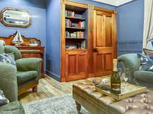 a living room with a couch and a bottle of wine at Going Coastal in Inverallochy