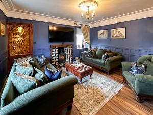 a living room with couches and a fire place at Going Coastal in Inverallochy