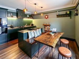 a kitchen with a wooden table and some chairs at Going Coastal in Inverallochy +20 photos