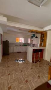 an empty room with a kitchen with a wooden floor at The Meadow View House in Oobi