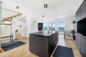 a kitchen with a black island in a room with windows at Luxury house with exclusive views in Vallendar