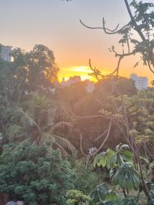 a sunset over a city with trees and buildings at ape 1qto centro in Cuiabá