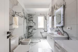 a white bathroom with a toilet and a sink at Luma Penthouses by Kondo Stays in Tirana +134 photos
