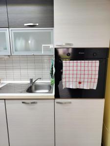 eine kleine Küche mit Spüle und Herd in der Unterkunft Donna Lucia in Giardini-Naxos