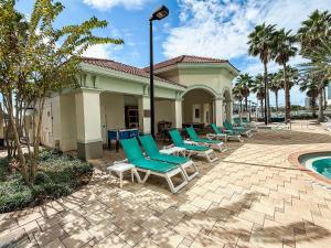 Modern Flat 4min from Universal Up to 4 Guests في أورلاندو: صف من كراسي الصالة الخضراء بجانب المسبح