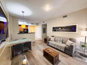 Modern Flat 4min from Universal Up to 4 Guests في أورلاندو: غرفة معيشة بها أريكة وطاولة