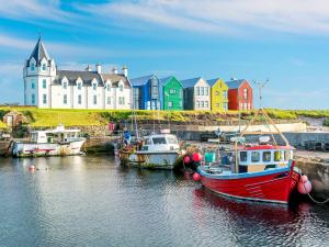 a group of boats in the water in front of a building at Gladstone Cottage in Castletown
