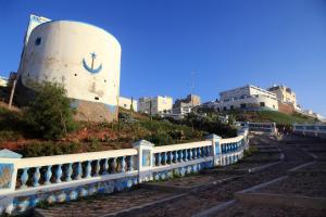 een wit hek naast een gebouw met een anker erop bij Auberge Azul Ifni in Sidi Ifni