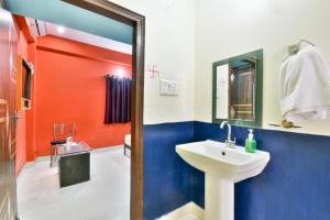 a bathroom with a sink and a red and blue wall at Magadh Imperial Guest House in Patna