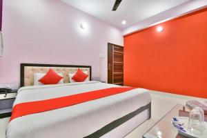 a bedroom with a large bed and a red wall at Magadh Imperial Guest House in Patna