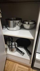 three pots and pans on a shelf in a kitchen at Studio at Tottinkatu in Savonlinna