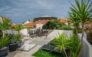 a patio with a table and chairs and plants at Apartman Kala-Two bedroom-Terrace in Sutivan