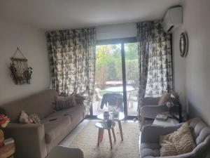 ein Wohnzimmer mit Sofas und einem Tisch und eine Terrasse in der Unterkunft chambre dans une residence à deux pas de la mer in Cannes + 1 Foto