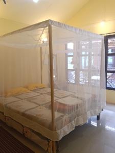 ein Bett mit Baldachin in einem Zimmer in der Unterkunft Nirvana Beach Cottages in Canacona