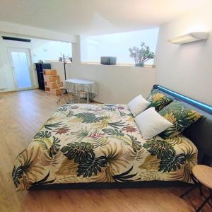 a bedroom with a bed with a colorful comforter at Studio 40 m2 avec sauna proche de Strasbourg in Mittelhausbergen