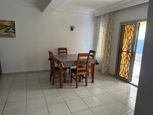 a dining room with a table and chairs and a window at LesOiseaux in Yaoundé