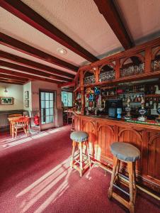 The Falcon Inn في Saint Mawgan: بار مع اثنين من المقاعد في الغرفة