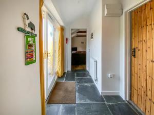 a hallway with a tile floor and a door at Wild Rose in Delabole
