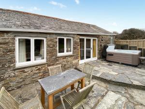 a patio with a table and chairs in front of a house at Wild Rose in Delabole