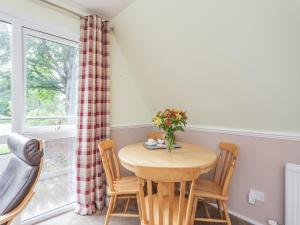 een eetkamer met een tafel en stoelen en een raam bij Gorse Lodge - Uk7050 in Glenurguhart