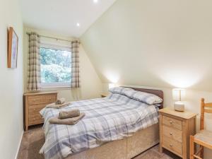 een slaapkamer met een bed en een raam bij Gorse Lodge - Uk7050 in Glenurguhart
