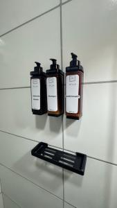 Tres botellas en un estante con un control remoto en Flat em Gravatá - Villa Monte Castelo, en Sairé