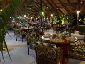 a restaurant with tables and chairs with people sitting at them at Hotel Villas Rio Mar in Dominical