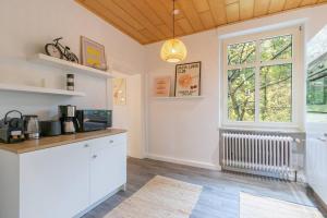 une cuisine avec des armoires blanches et une fenêtre dans l'établissement Altbauwohnung in Mayen im Grünen, à Mayen
